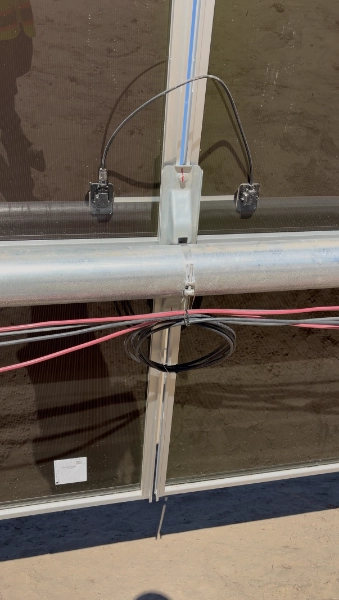 Pre-assembled solar wire harnesses laid out along a tracker row before installation
